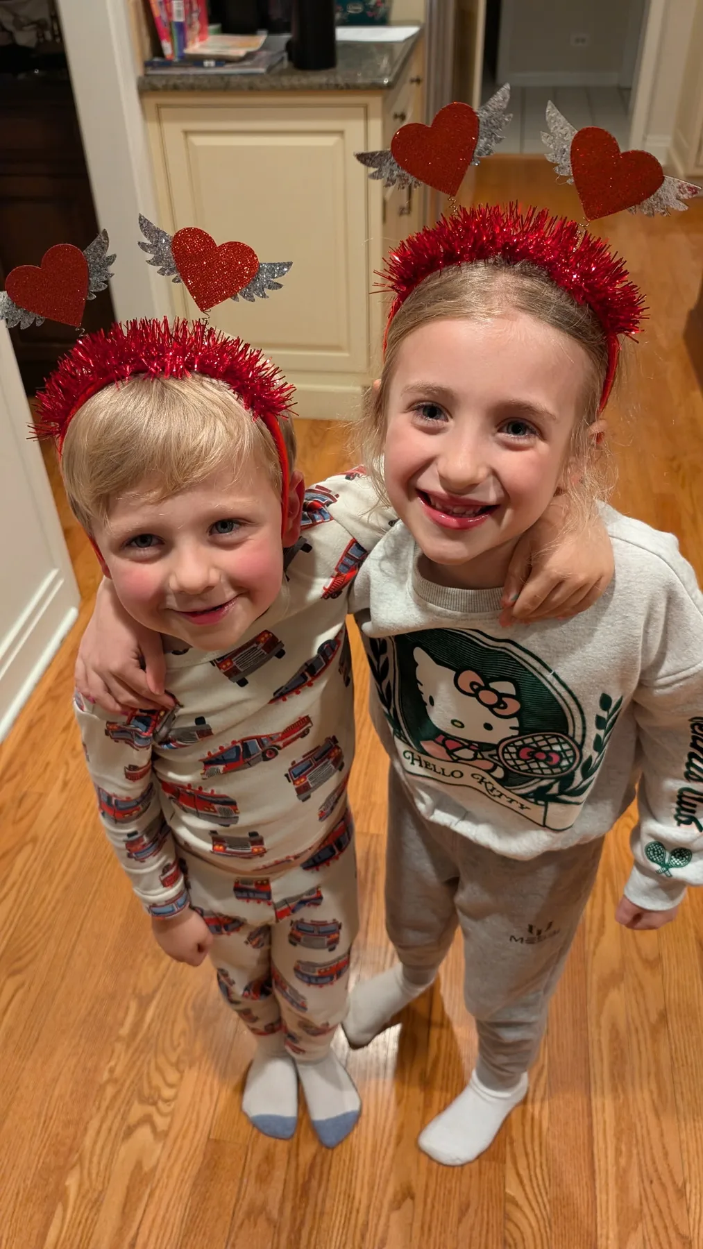 Abigail and Caleb wearing heart headbands, laughing